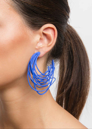 Blue hoop earring worn by a person with a neutral background