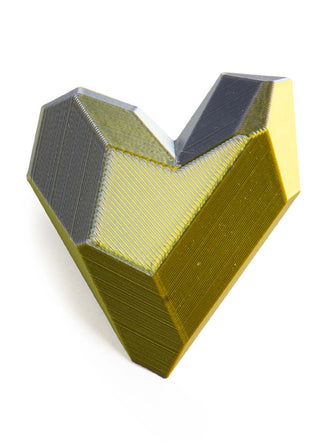 Geometric heart-shaped object with a metallic finish on a white background