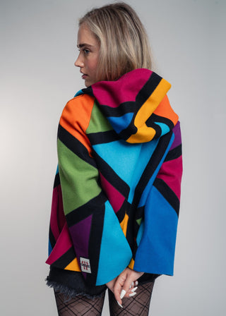 Discover our handcrafted abstract multi-color hooded jacket made of premium Burel wool. Each piece features a unique pattern, expert tailoring, and vibrant style. Perfect for bold fashion lovers.
