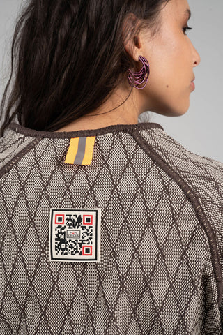 Person wearing a textured garment with a QR code patch on the back
