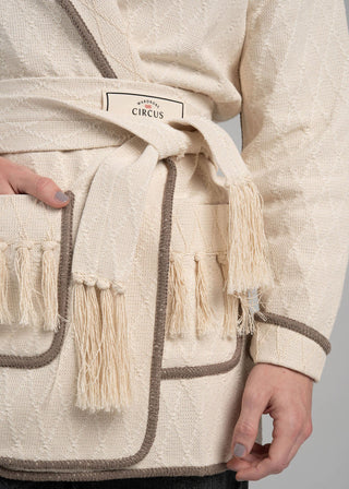 Beige robe with tassels and a visible brand label on a plain background