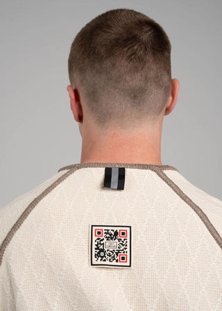 Person wearing a beige shirt with a QR code label on the back against a gray background