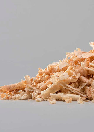 Close-up of shredded Swiss pine wood chips on a gray background