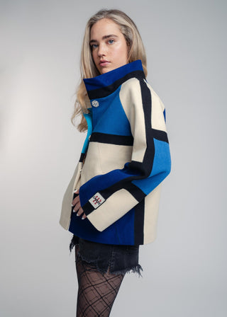 Woman wearing a blue and beige patterned coat on a gray background