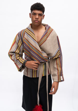 A model wearing a beige wrap-style jacket with multicolored striped patterns and a matching tie belt, paired with black pants, against a plain white background.