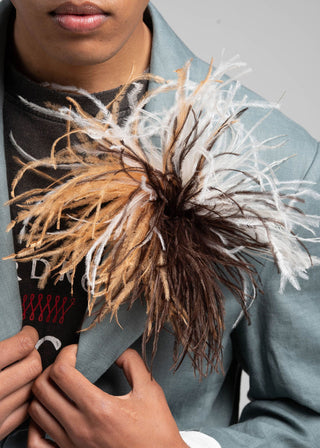 Person holding a decorative bouquet with brown, white, and black elements.
