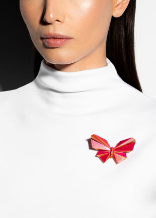 Red bow tie on a white turtleneck against a black background