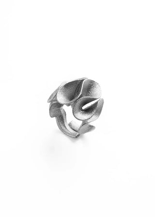 A textured silver ring designed in the shape of overlapping calla lilies, photographed on a seamless white background.