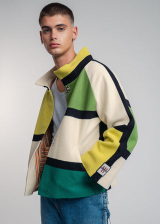 Man wearing a colorful sweater with a plain background