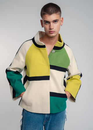Man wearing a colorful jacket with geometric pattern on a plain background