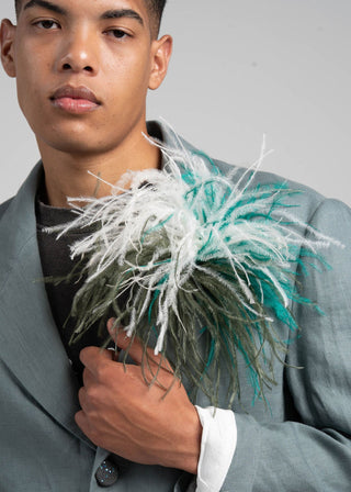 Man holding a bouquet of flowers against a plain background