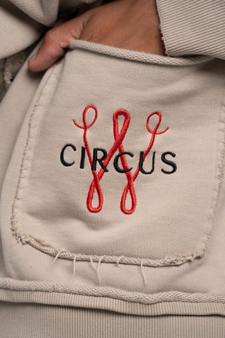 Beige jacket with 'CIRCUS' and red letters embroidered on a pocket.