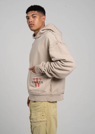 Person wearing a beige hoodie with text on a plain background