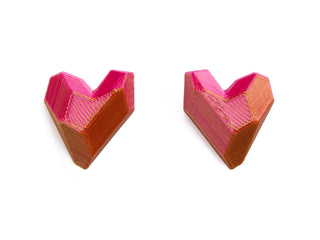 Two pink and orange geometric objects on a white background