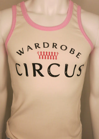 A cream-colored tank top with pink trim and a graphic print reading 'WARDROBE CIRCUS' in black, displayed on a mannequin torso with blue jeans partially visible.