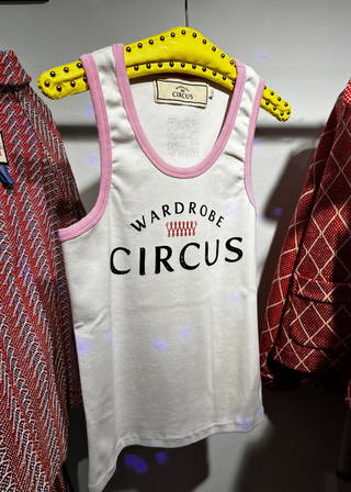 White tank top with 'Wardrobe Circus' text on a yellow hanger against a white background.