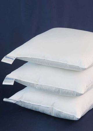 Three white pillows stacked on a dark blue background