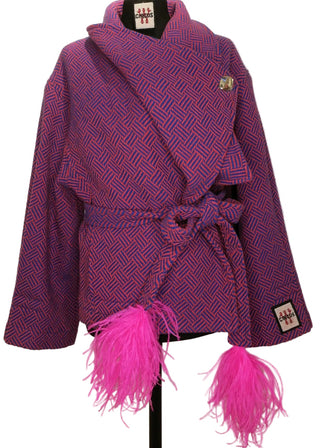 A purple patterned jacket with bright pink feather trim and a matching tie belt, displayed on a black dress form against a plain beige background.