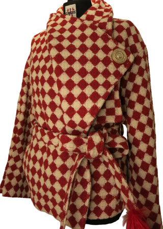 A red and cream diamond-patterned coat displayed on a black dress form mannequin against a plain beige background.