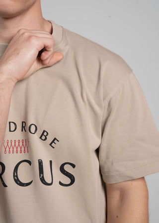 Beige t-shirt with 'WARDROBE CIRCUS' text and logo on a plain background