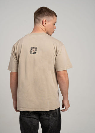 Man wearing a beige t-shirt with a QR code on the back against a plain background