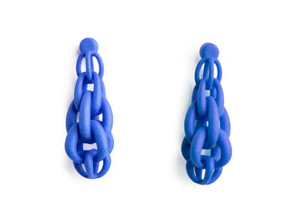 Blue chain 3D printed earring worn by a person with dark hair.