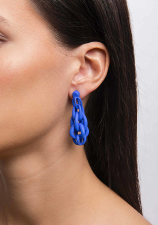 Blue chain 3D printed earring worn by a person with dark hair.