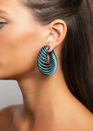 Close-up of a woman wearing a nebula spiral earring with a neutral background