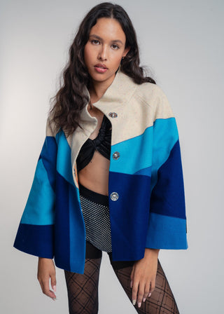 Woman wearing a colorful jacket with a plain background