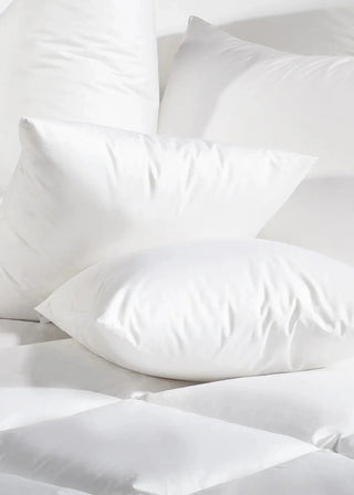 White pillows and comforter on a white background