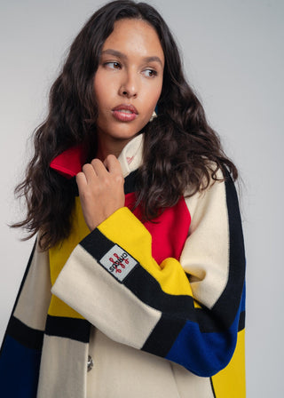 Woman wearing a colorful scarf with a pattern on a plain background