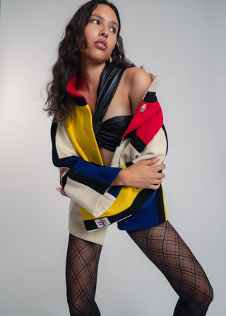 Woman wearing a colorful jacket with a plain background