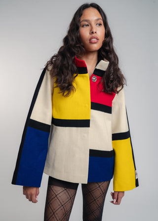 Woman wearing a colorful jacket with a neutral background