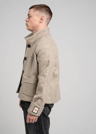 Man wearing a beige textured coat on a gray background