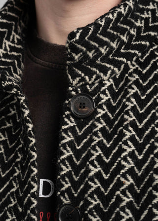 Close-up of a black and white patterned coat with buttons.