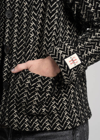 Black and white patterned jacket with a brand label on a gray background