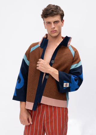 Man wearing a brown and blue spade jacket with a white background