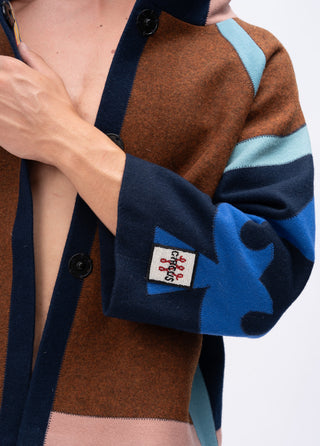 Close-up of a person wearing a brown and blue wool jacket with a spade design 