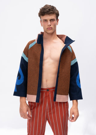 Man wearing a brown and navy jacket with blue accents on a white background