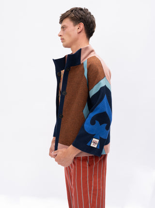 Man wearing a colorful jacket with a blue abstract design on a white background