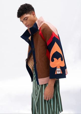 Person wearing a multi-color wool jacket with a spade design on a white background