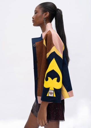 Woman wearing a multi-color jacket with a yellow and blue design on a white background