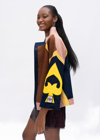 Woman wearing a multi-color wool jacket with a yellow and blue design on a white background