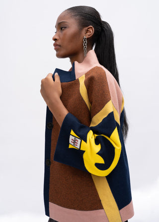 Woman wearing a colorful patterned wool jacket with a yellow and blue design on a white background