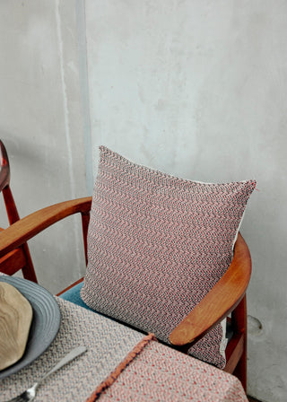 Textured pillow on a wooden chair with a neutral background