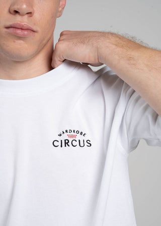 Person wearing a white t-shirt with 'Circus' logo on a plain background