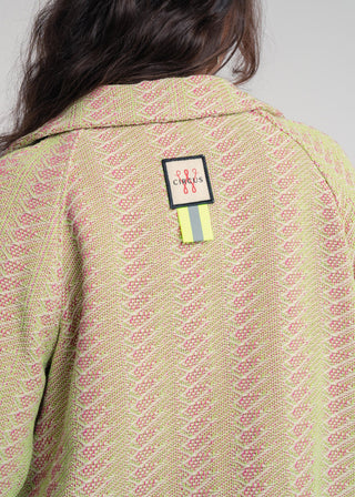 Back view of a unisex short jacket in premium cotton with a bold light green and hot pink duo-color design, featuring interchangeable buttons for a customizable look.
