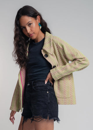 Side view of a unisex short jacket in premium cotton with a bold light green and hot pink duo-color design, featuring interchangeable buttons for a customizable look.