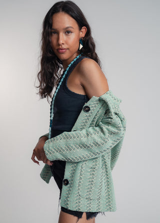 Side view of a unisex short jacket in premium cotton with a bold mint and navy duo-color design, featuring interchangeable buttons for a customizable look.